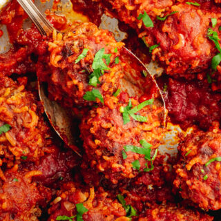 A skillet with porcupine meatballs on a spoon.