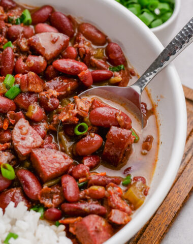 red beans and rice in a white bowl, with garnish of scallions