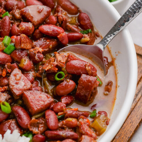 red beans and rice in a white bowl, with garnish of scallions