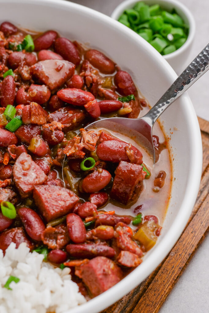 red beans and rice in a white bowl, with garnish of scallions