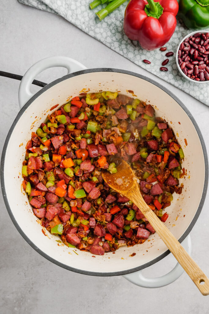 Onion, Celery and Peppers being added to the pot to be stirred around.