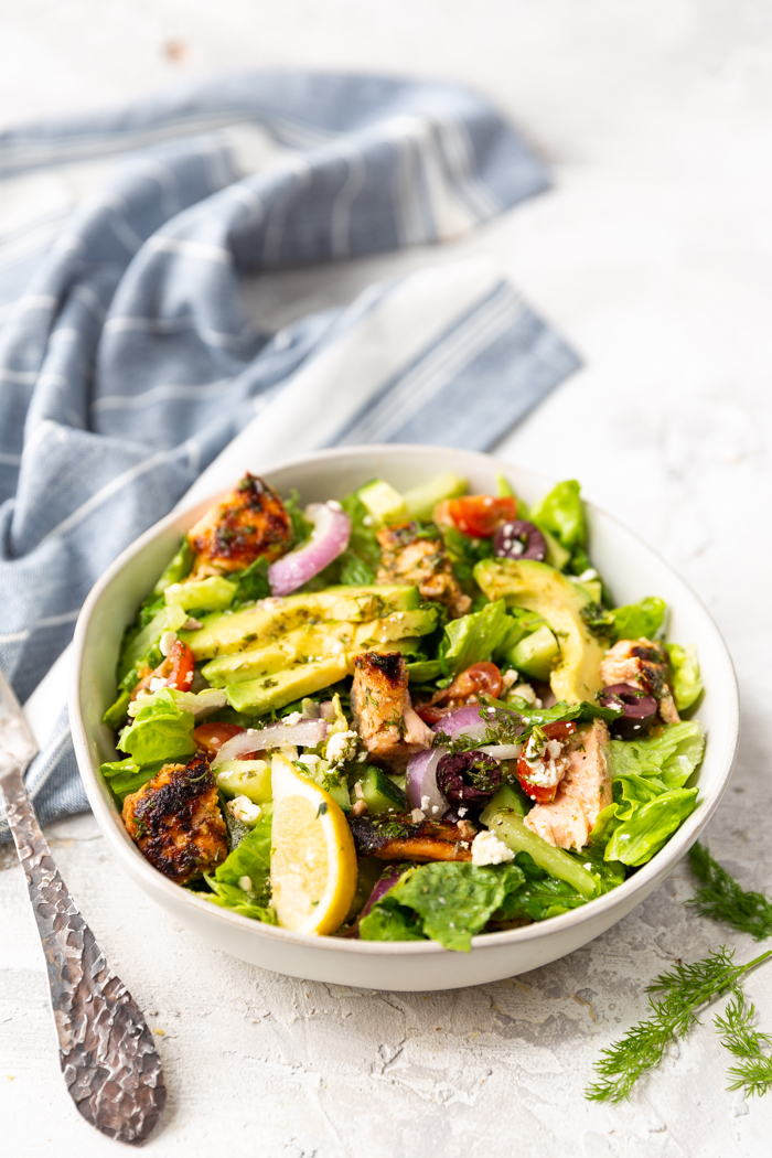 A white bowl full of salmon avocado salad