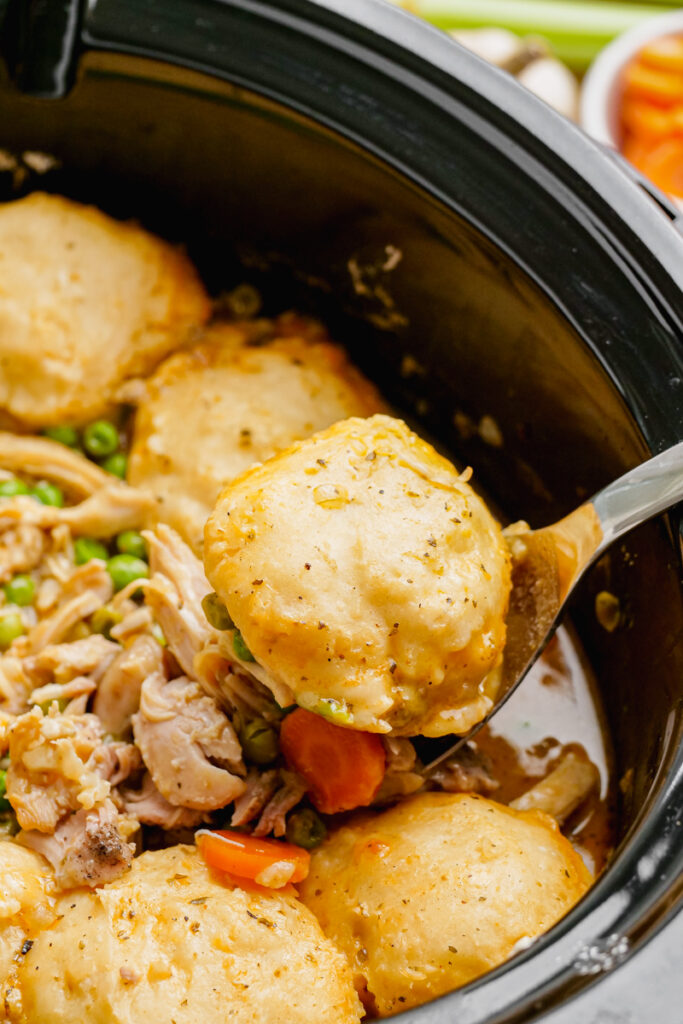 A crock pot with chicken and dumplings in it.