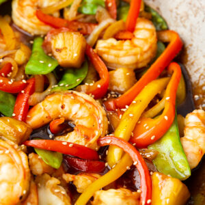 a wok full of shrimp and vegetables