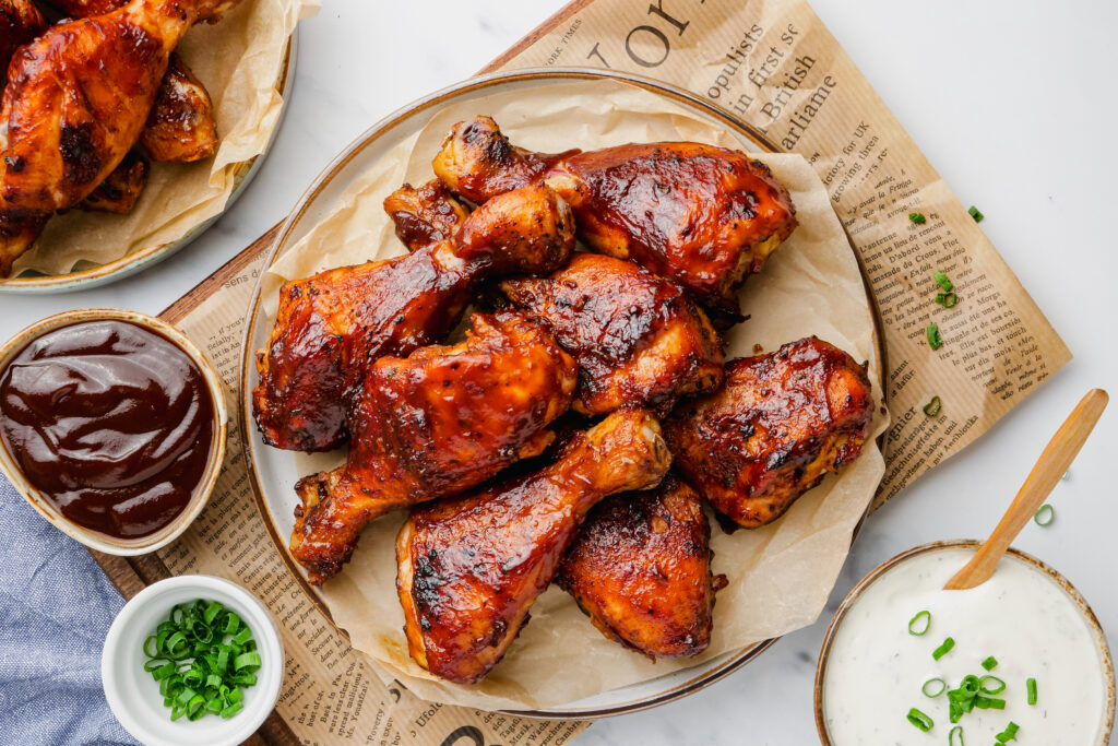 Slow Cooker BBQ Drumsticks on a plate with sauces to the side