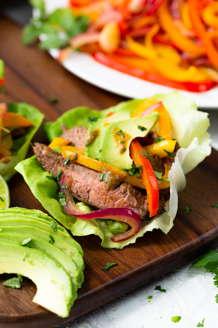 steak fajita lettuce wraps on a brown cutting board 