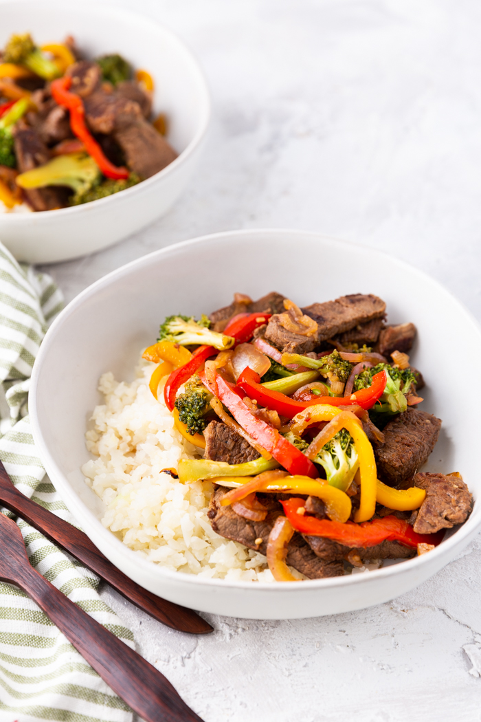 furthest away view of the steak stir fry in a bowl with another bowl behind