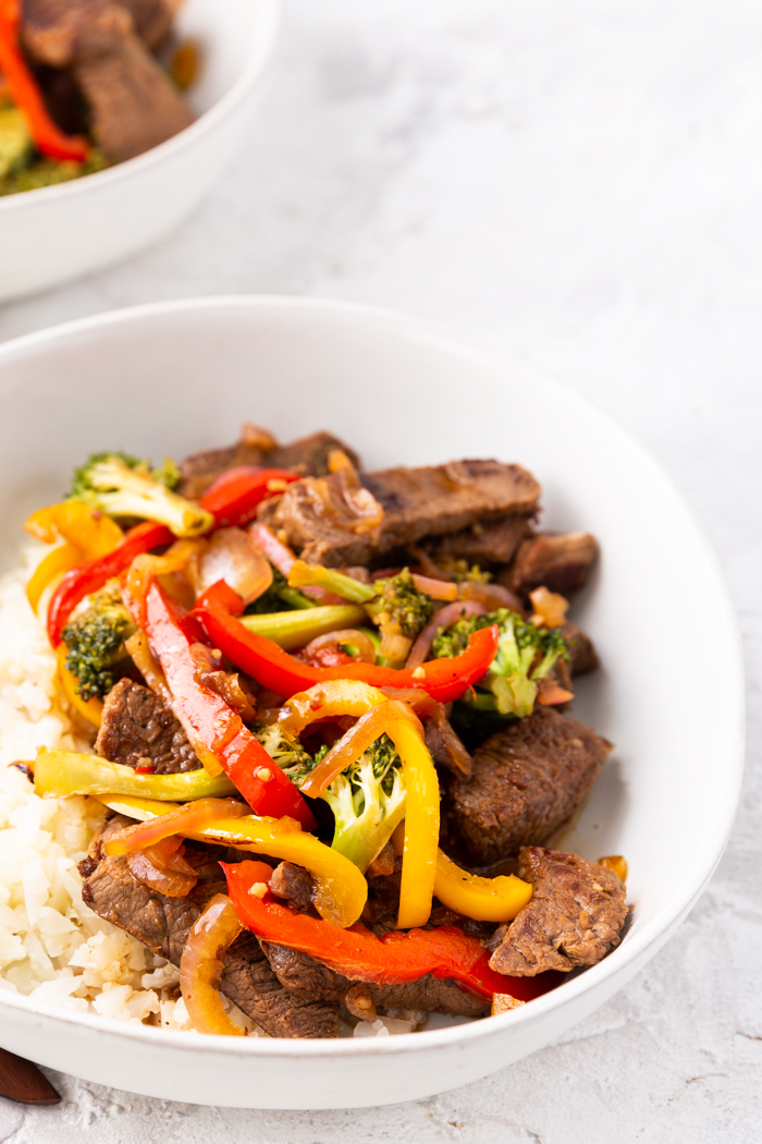 view of steak stir fry in the white bowl at a closer birds eye angle