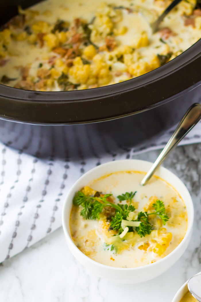 zuppa toscana soup in a bowl with slow cooker next to it