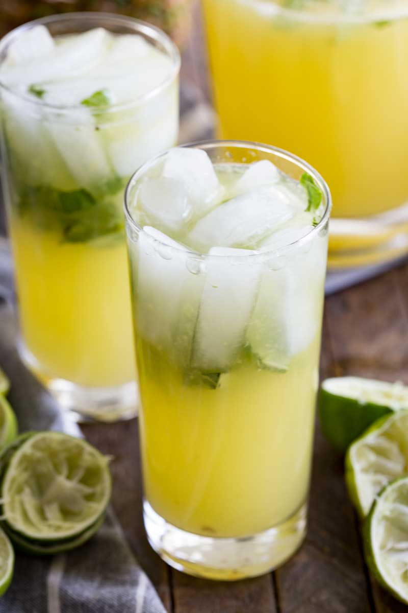 Tall glass of pineapple limeade with basil