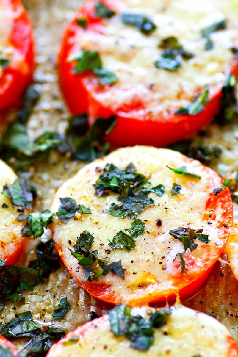 These Baked Parmesan Basil Heirloom Tomatoes are covered in TONS of gooey cheese and fresh basil for one super-simple AND healthier summer side dish! You won't be able to resist eating them straight off the sheet.