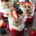 A breakfast parfait with a 3 berry compote, greek yogurt, granola, and chia