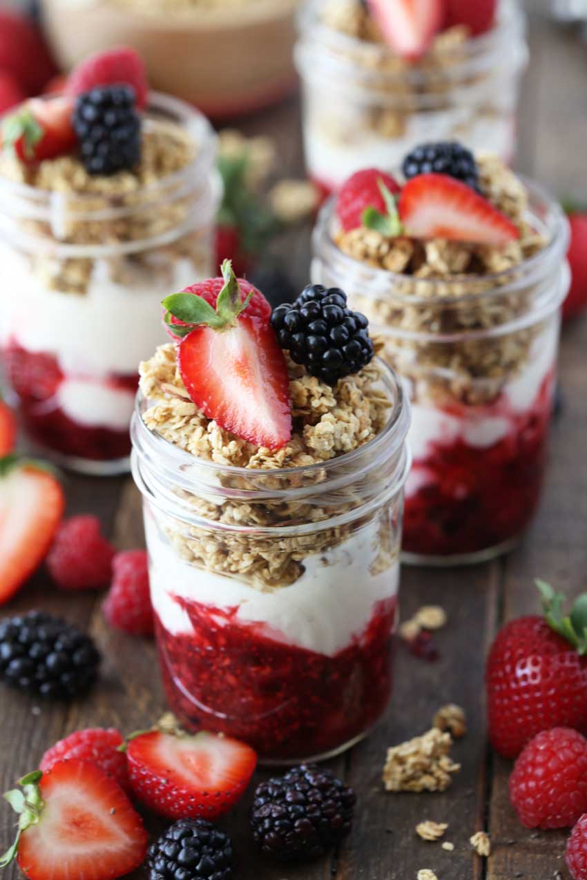 A breakfast parfait with a 3 berry compote, greek yogurt, granola, and chia