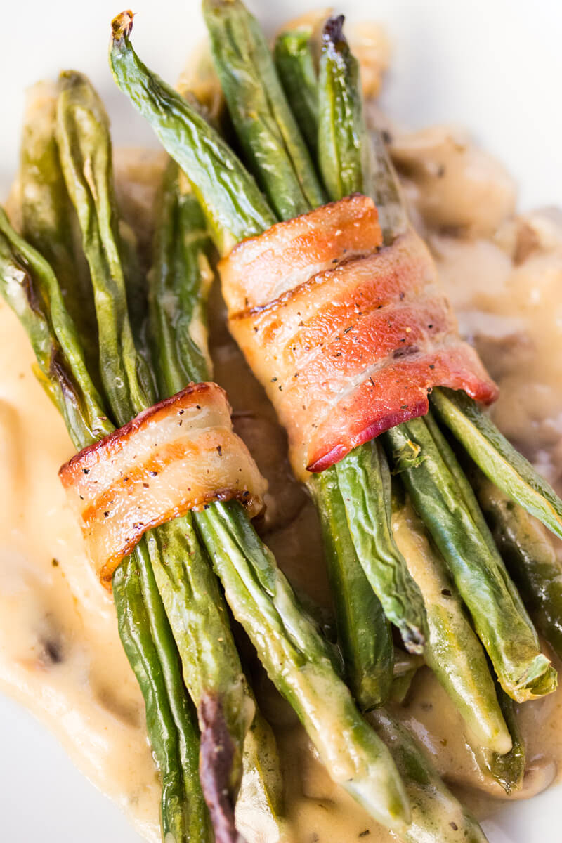 Bacon Wrapped Green Beans with Mushroom Gravy: Features tender green beans that are wrapped in bacon and baked atop a creamy delicious mushroom sauce. Umm good!