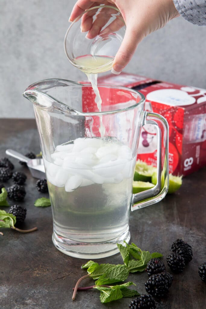 Pouring lime juice into a pitcher