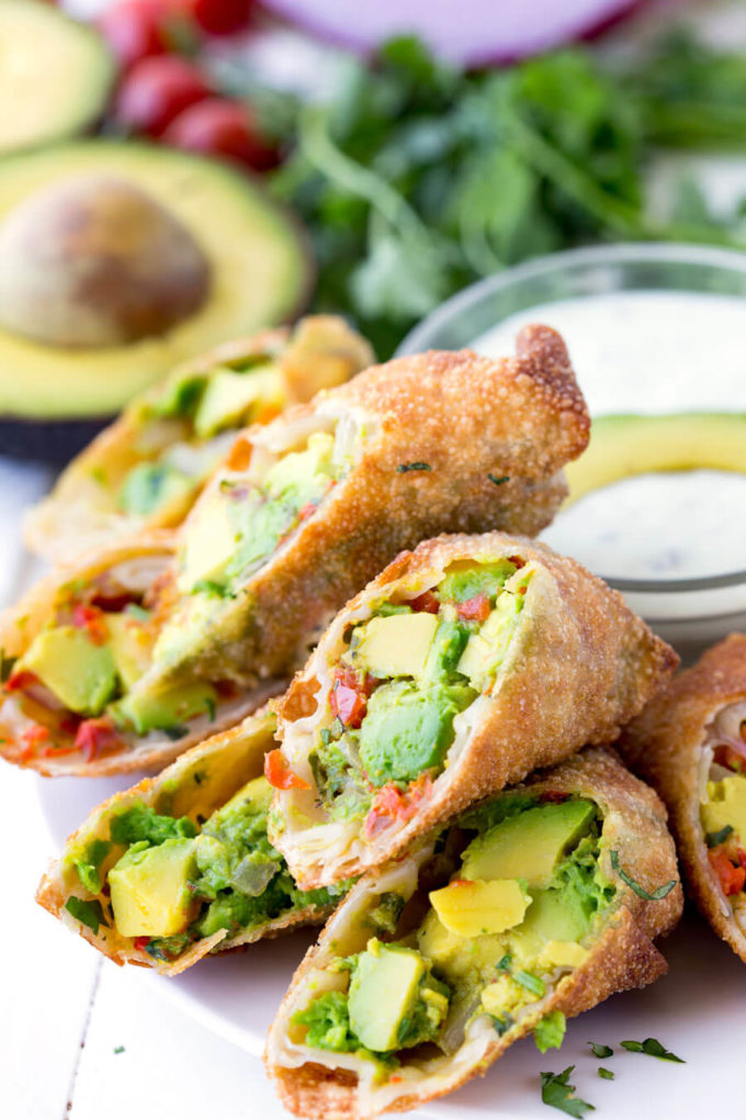 Avocado Egg Roll Dipping Sauce: Crunchy egg roll wrapper filled with chunks of California Avocados, cilantro, tomatoes, red onion, and roasted red peppers; dipped in a creamy avocado ranch dipping sauce!