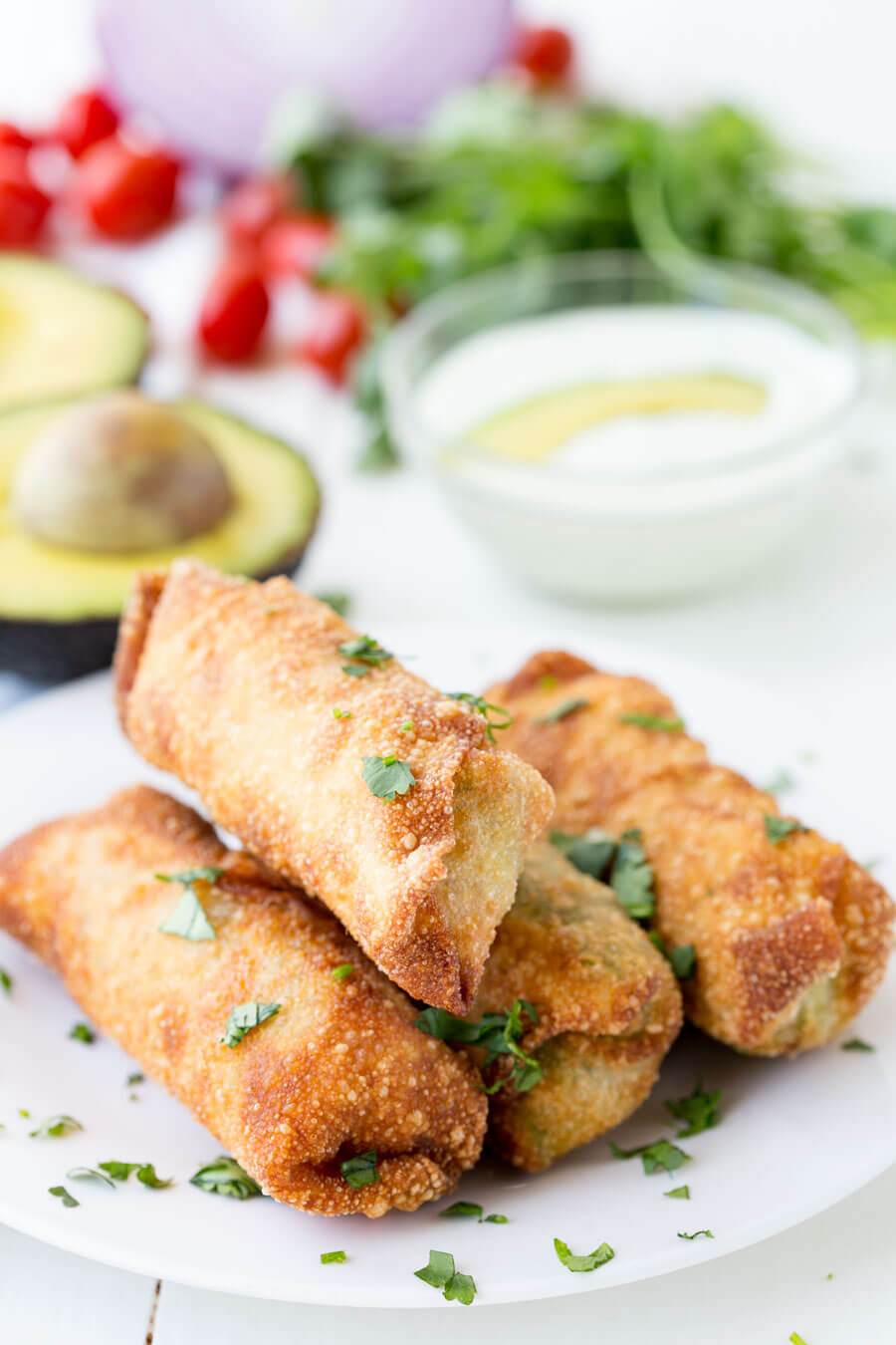 Avocado Egg Rolls: Crunchy egg roll wrapper filled with chunks of California Avocados, cilantro, tomatoes, red onion, and roasted red peppers; dipped in a creamy avocado ranch dipping sauce!