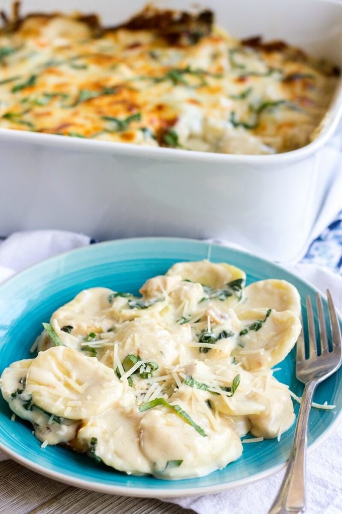 Cheesy Chicken Alfredo Ravioli Casserole is a creamy pasta bake that's loaded with chicken & spinach and is sure to leave cheese lovers drooling!