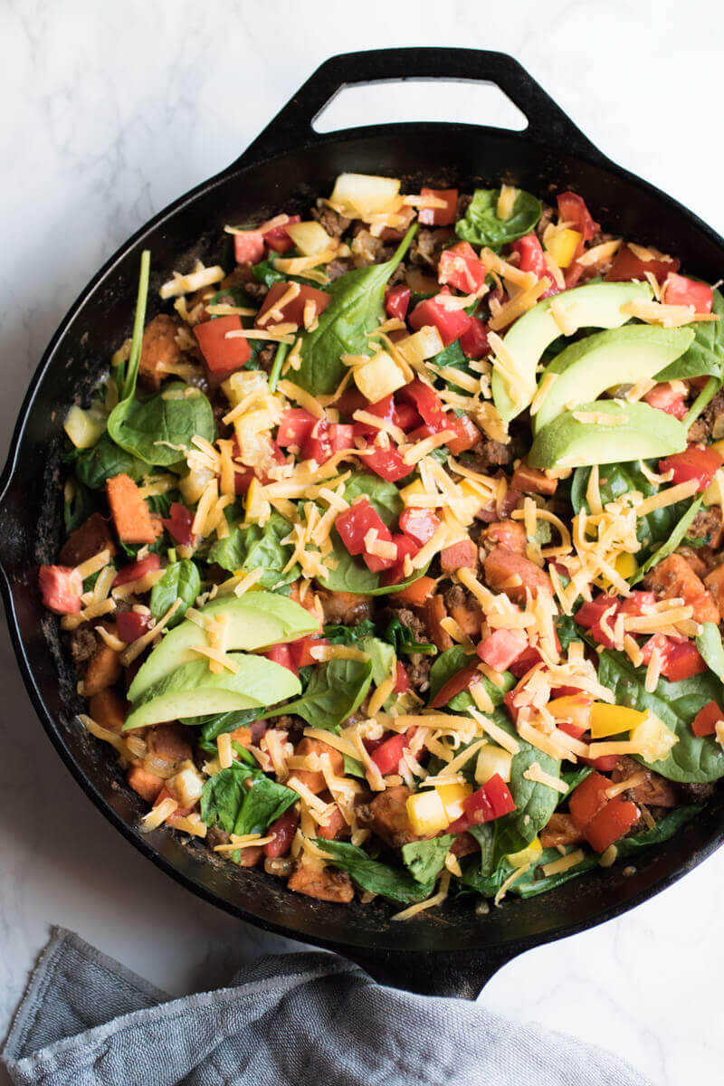 Southwestern sweet potato and ground beef skillet is loaded with fresh veggies and topped with cheese and avocado. A healthy, easy, and insanely delicious dinner that your whole family will love. Ready in 30 minutes!