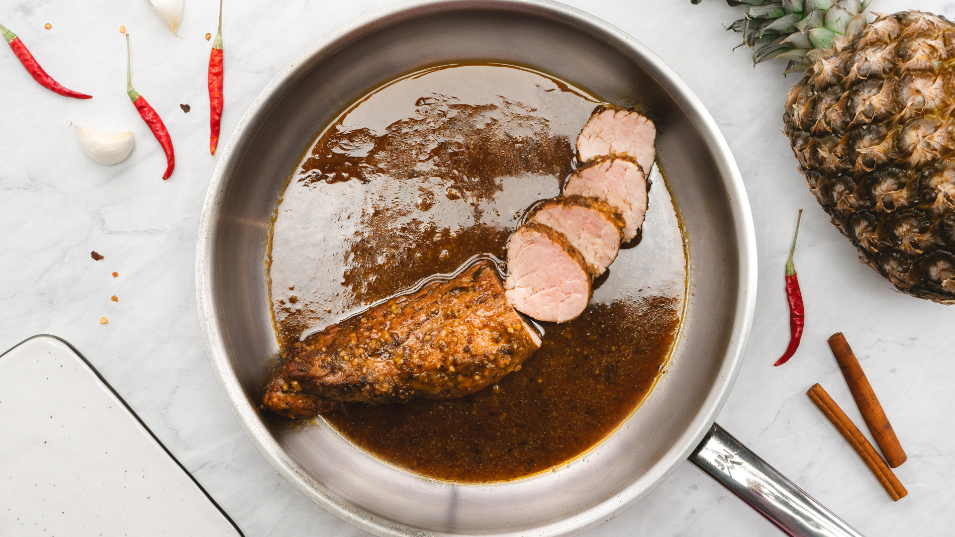 A skillet with an island style pork tenderloin 