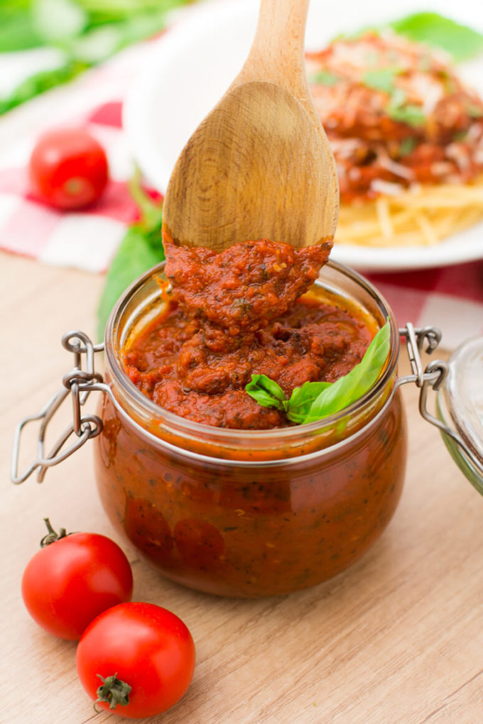 Homemade Spaghetti Sauce in a glass jar with a wooden spoon