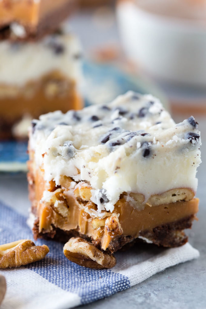 Delicious layered cookie bars with caramel, cookie, and frosting, topped with chocolate. Cookies and cream caramel layer bars