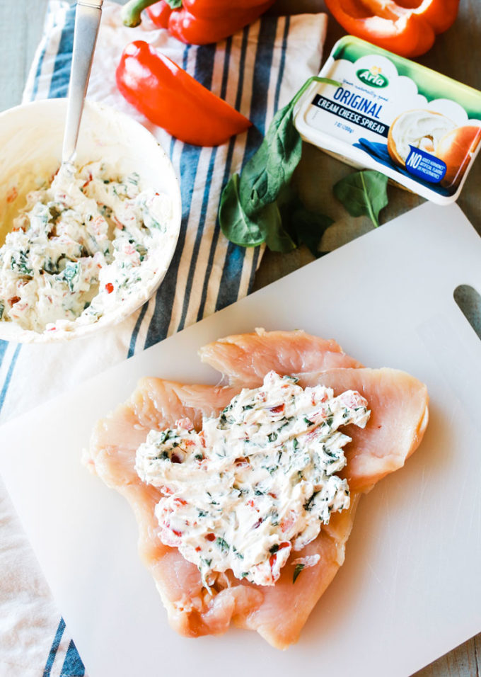 A sliced chicken breast stuffed with cream cheese and roasted red peppers then cooked up