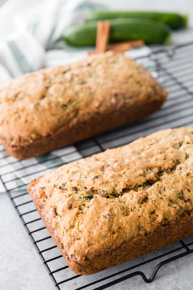 Letting two loaves of zucchini bread cool on a cooling rack for zucchini bread