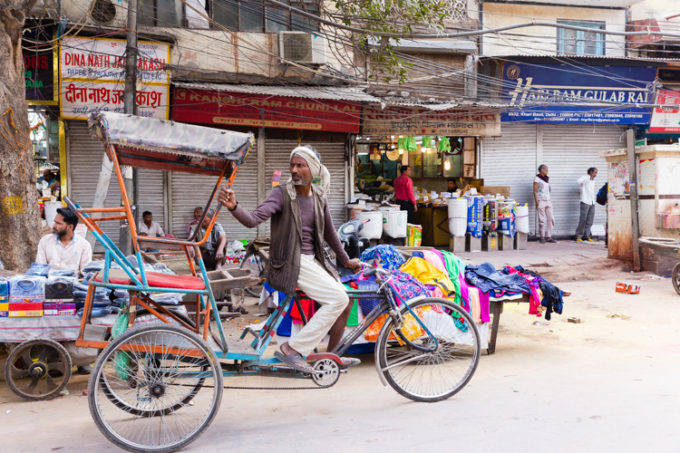 Riding a bicycle, driving a tuk tuk, the transportation of India. 