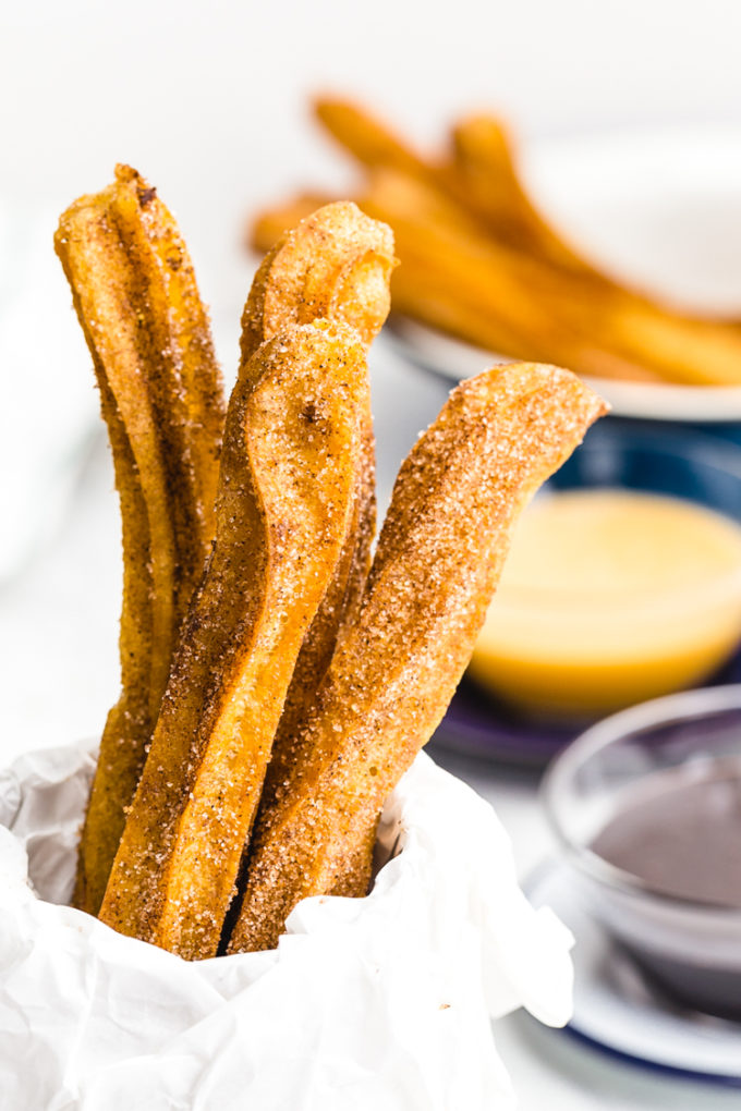Delicious fried churros rolled in cinnamon and sugar and dipped in chocolate and caramel sauces. Mexican churros that are easy to make