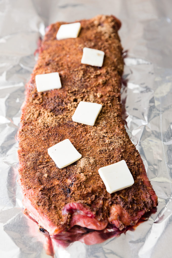 Ribs partially cooked and dotted with butter