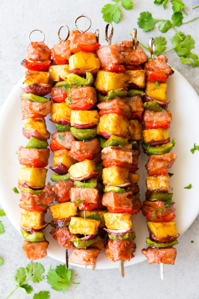 Deliciously sticky BBQ Pork Kabobs, with pineapple, green and red peppers, red onion, and bbq pork, topped with cilantro