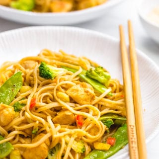Easy garlic chicken lo mein in a white dish with chopsticks