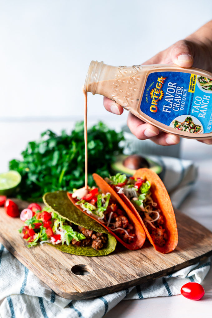 Ortega flavor craver sauce being poured onto ground beef tacos