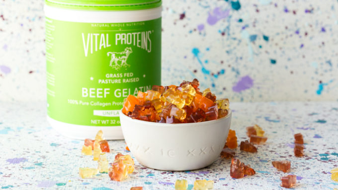 A bowl full of protein gummy bears and a bottle of collagen protein beef gelatin