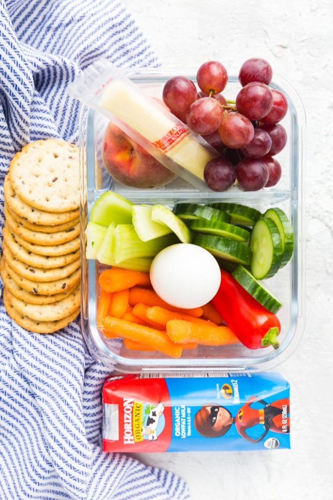 Horizon string cheese, fruit grapes and peaches, and vegetables, hard boiled egg, crackers, and milk