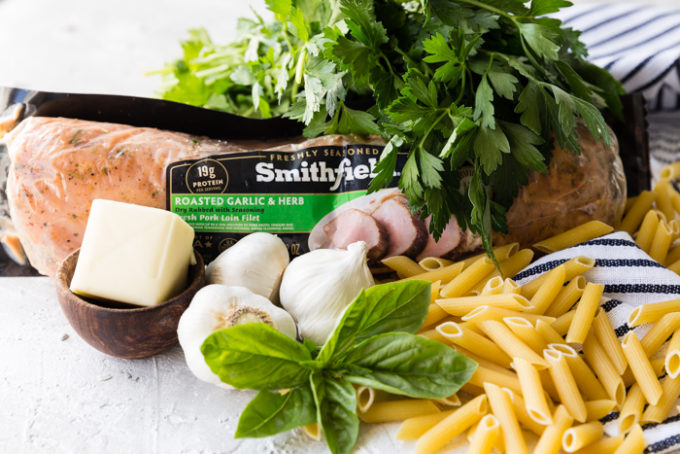A package of Smithfield premartinated pork, penne pasta noodles, garlic, basil, parsley, and butter