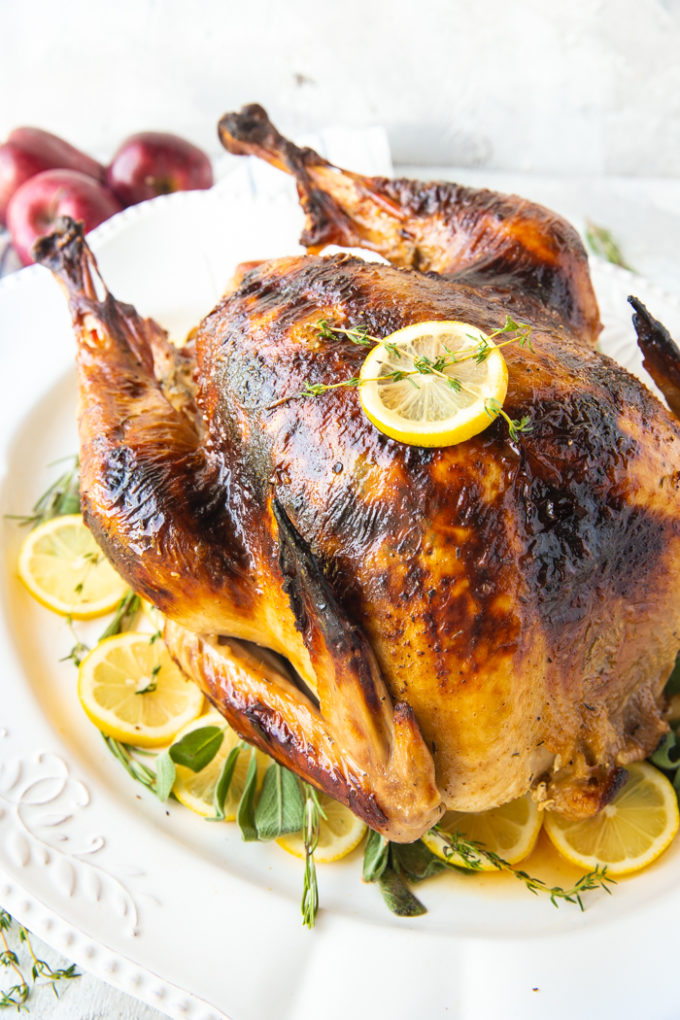 Roast Turkey - How to cook a turkey, a lovely roast turkey on a white platter with fresh herbs and sliced lemons