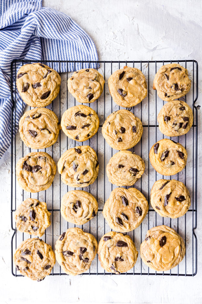 Traeger smoked chocolate chip cookies on a cooling rack, with striped napkin in the corner