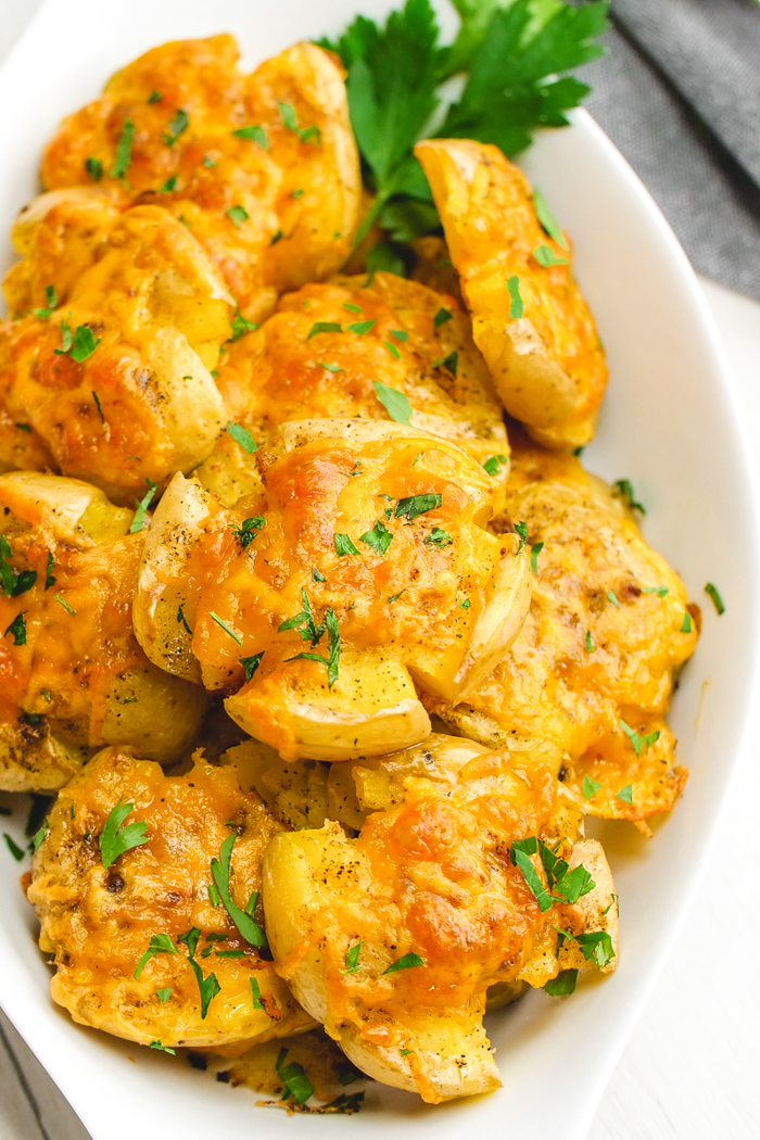 A tray of smashed potatoes with parsley garnish