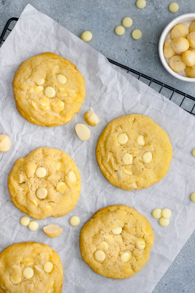 A cooking rack covered in white chocolate macadamia nut cookies