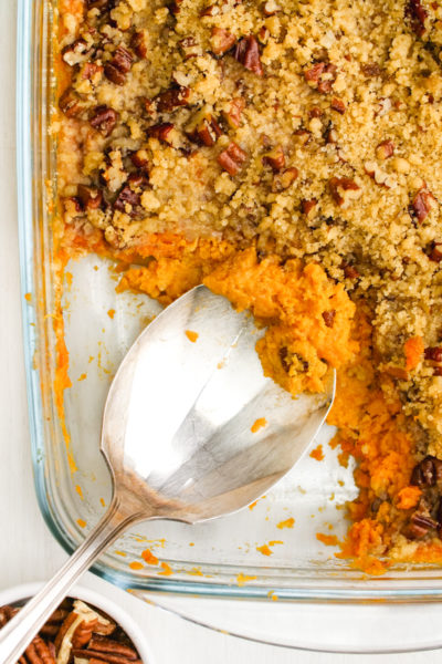 Sweet Potato Casserole in a baking pan with a serving spoon