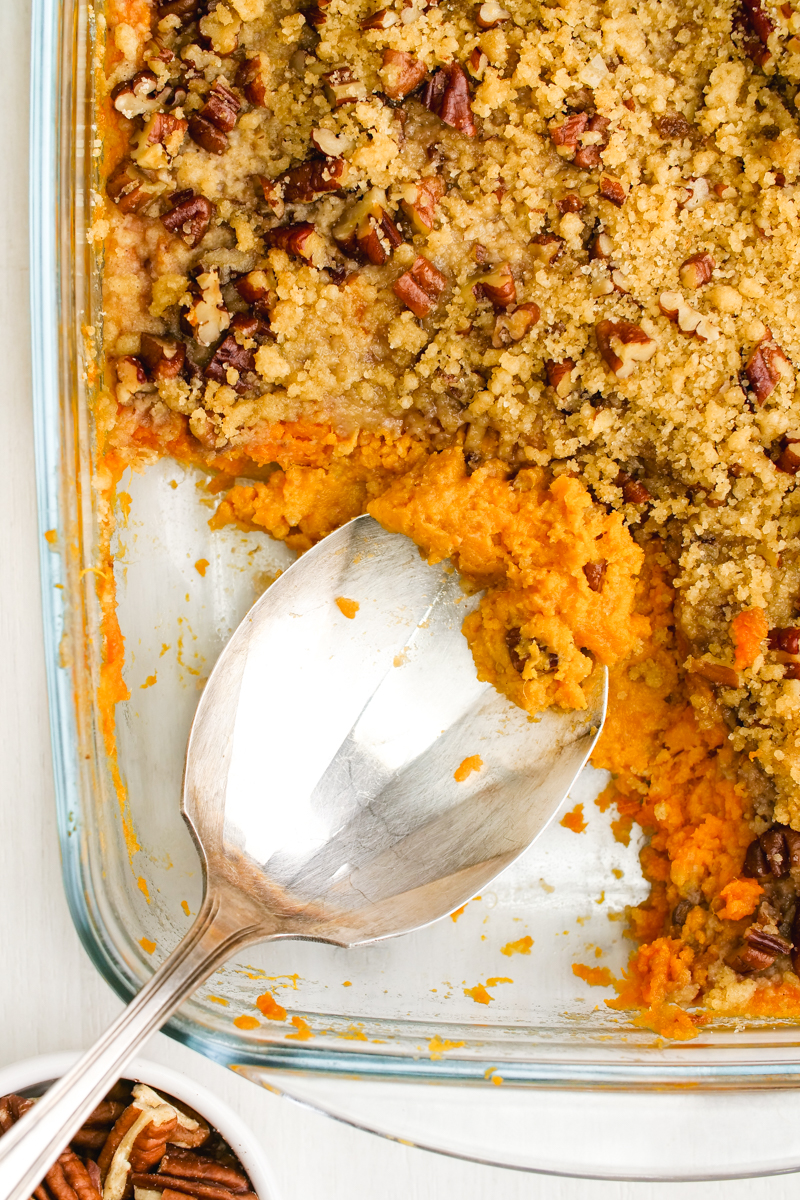 Sweet Potato Casserole in a baking pan with a serving spoon