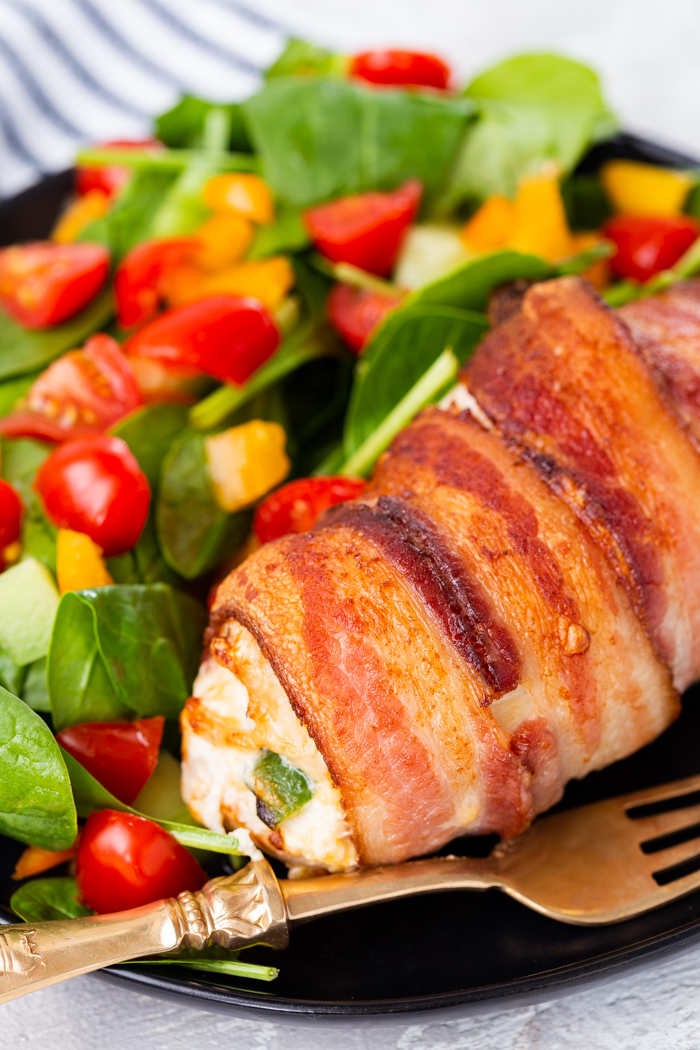 Air fryer jalapeno stuffed chicken breast keto low carb on a plate with a spinach salad