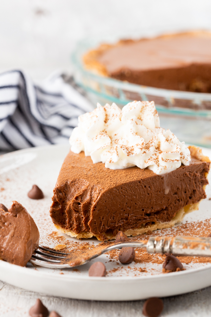 Creamy, delicious chocolate pie, with whipped cream, forks, and chocolate chunks