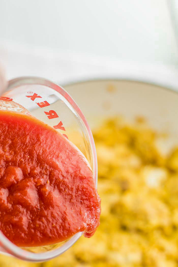 Add tomatoes to a pan of butter chicken and let it simmer