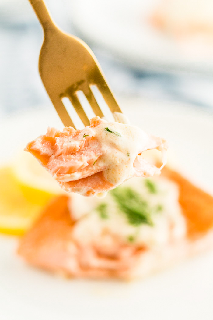 A fork full of salmon made with a creamy lemon dill sauce