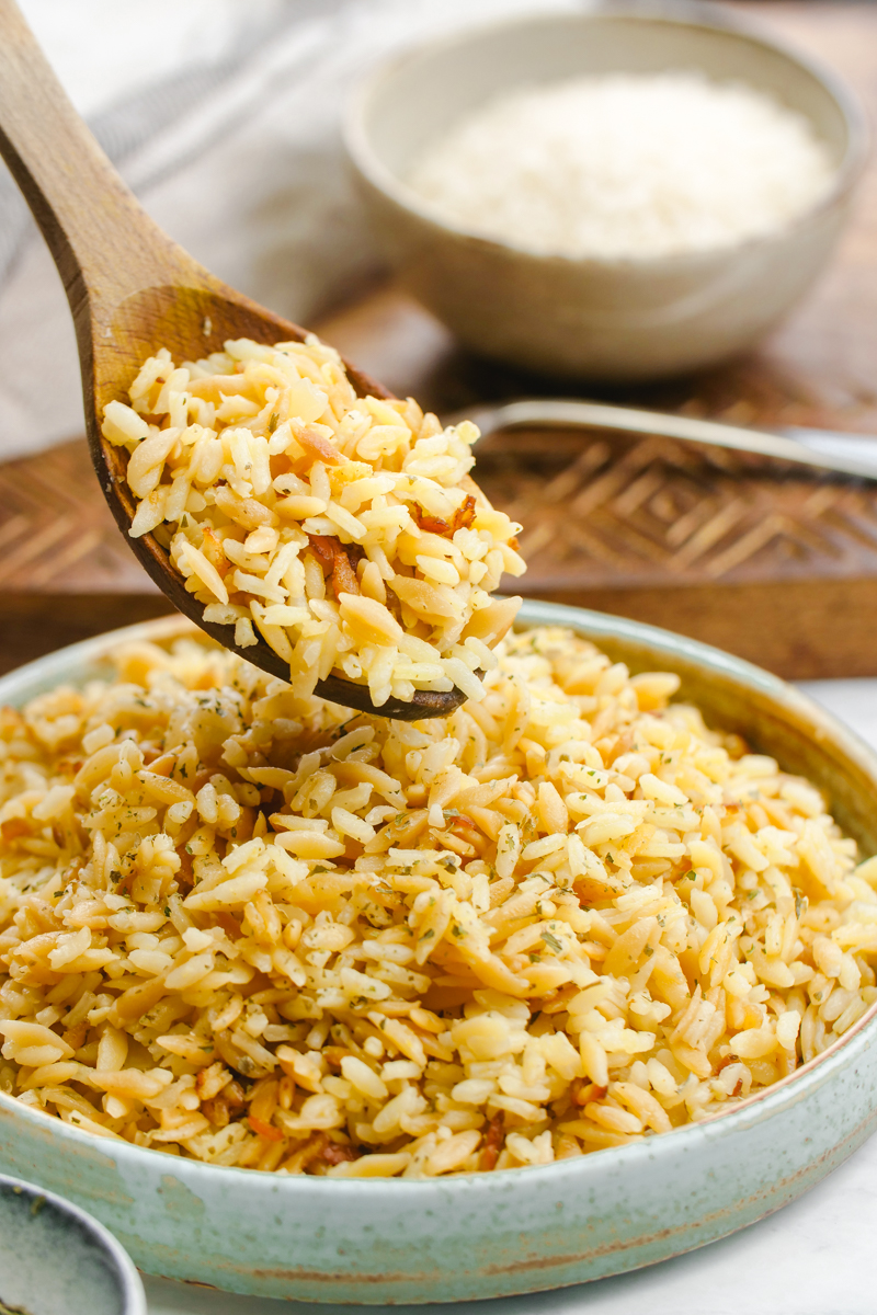 Easy to make rice pilaf in a bowl with a wooden spoon scooping some out