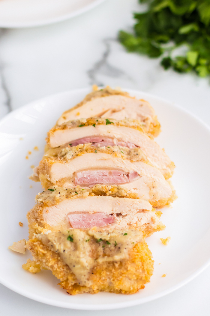 A piece of Chicken Cordon Bleu, all sliced up, the ham and cheese on the inside is easy to see