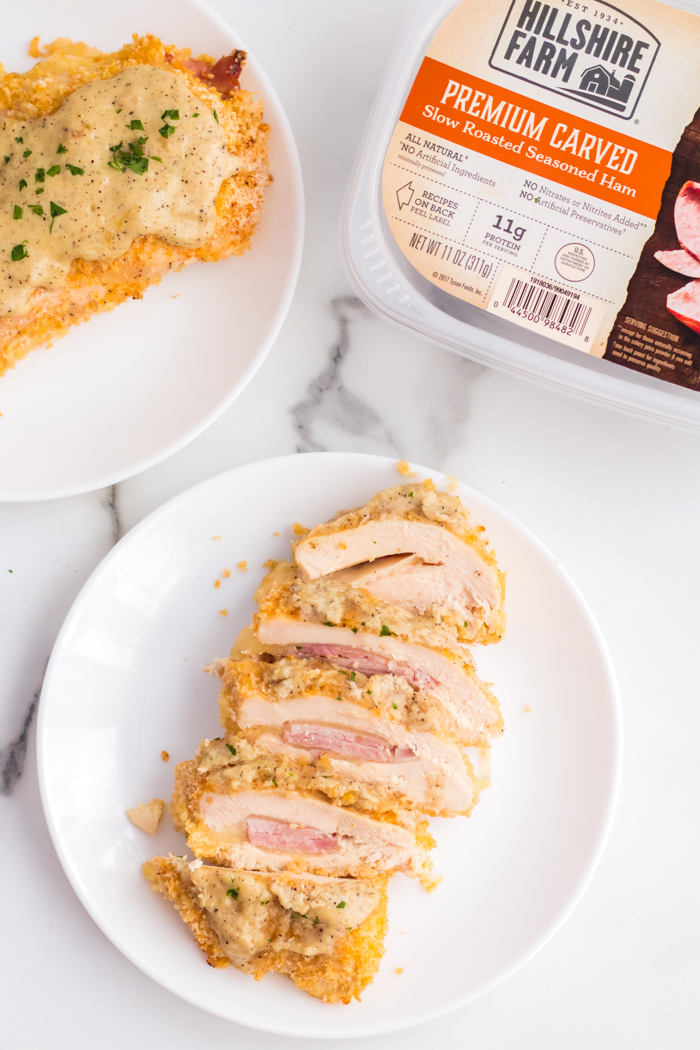 Chicken cordon bleu on a white plate, all sliced up.